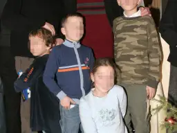 Zbigniew Zamachowski dzieci: czwórka dzieci w różnym wieku, jedno w bluzie moro, drugie w granatowym sweterku, trzecie w błękitnej bluzce, czwarte w ciemnej sukience.