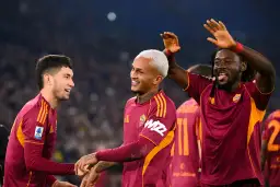Piłkarze AS Roma świętują zwycięstwo nad Genoą CFC. Radość na twarzach zawodników, jeden z nich podnosi ręce w geście triumfu.