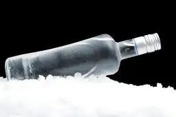 Butelka wódki w lodzie, ilustrująca, dlaczego wódka nie zamarza w domowej zamrażarce – fizyka alkoholu.