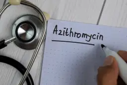 Stetoskop i notatnik z napisem "Azithromycin". Lekarz przygotowuje receptę.