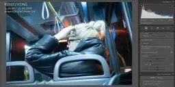 Kobieta w czarnej kurtce siedzi w autobusie, poprawiając włosy. Widać suwaki redukcji szumów w programie do edycji zdjęć.