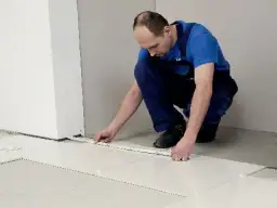 Fachowiec układa płytki 60x60, dbając o równe fugi. Wzory układania płytek są kluczowe dla estetyki.