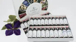 Caja de flores de Bach para perros con varias botellas de esencias florales y una flor morada.