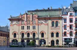 Elegancka fasada Teatru Starego w Krakowie z ozdobnymi detalami i łukowymi oknami.