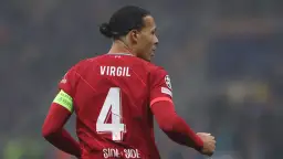 Piłkarz Virgil van Dijk w czerwonej koszulce Liverpoolu z numerem 4 i opaską "No to racism".