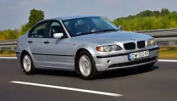 Srebrne BMW E46 330i jedzie po autostradzie, za kierownicą siedzi mężczyzna.