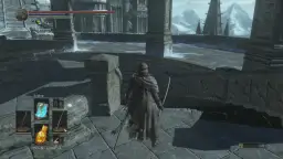 Postać w zniszczonym płaszczu z dwoma mieczami na tle majestatycznych gór i budowli, przypominających Anor Londo.