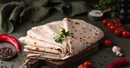 Stos cienkiego, puszystego lawaszu, co to jest? Idealny do wrapów, z pomidorkami, papryczką i ziołami.