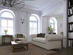 Elegancki salon z sofą, fotelem i książkami na półce.