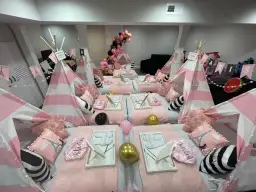 Urocze namioty tipi w różowo-białe paski, poduszki z Wieżą Eiffla i balony tworzą magiczne **pomysły na nocowanie** dla dziewczynek.