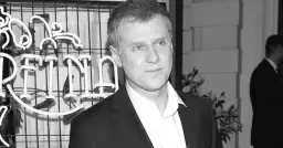 Krzysztof Reszpondek, znany z walki z chorobą, na tle neonowego napisu.