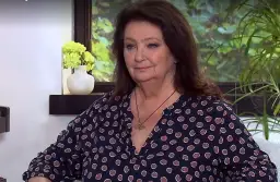 Anna Dymna, córka aktorki, w granatowej bluzce w brązowe kropki, z wisiorkiem na szyi.