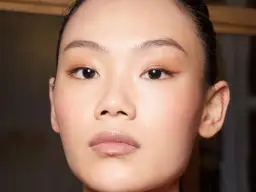 Nahaufnahme eines Gesichts mit makelloser Haut und dezentem Make-up.