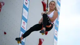 Zawodniczka wspina się po ścianie podczas zawodów o puchar świata we wspinaczce sportowej.