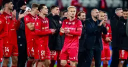 Piłkarze w czerwonych strojach, z numerami 14, 91, 99, 4, 6, klaszczą. Czy Widzew jest w Ekstraklasie?