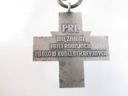 Srebrny krzyż z napisem "PRL WIĘŹNIOM HITLEROWSKICH OBOZÓW KONCENTRACYJNYCH".