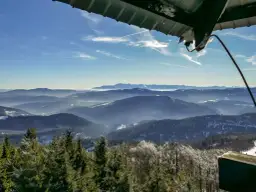 Widok z wieży widokowej na Beskid Wyspowy. W dole lasy i doliny, w oddali pasmo górskie. To najładniejszy szlak na Mogielicę.