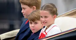 Księżniczka Charlotte uśmiecha się, siedząc w karocy obok swoich braci.