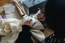 Ręce z pierścionkami szyją na maszynie, tworząc puszysty ogon lisa.