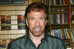 Chuck Norris, którego wiek nie ma znaczenia, bo jest niezniszczalny, pozuje na tle swoich książek.