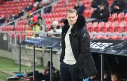 Trener GKS Tychy w zimowej kurtce, z uwagą obserwuje boisko. Czy to zapowiedź udanych gks tychy transfery?