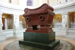 Grobowiec Napoleona w paryskim Invalides. Monumentalny sarkofag z czerwonego porfiru, otoczony rzeźbami.