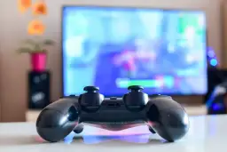 Czarny pad DualShock 4 na białym blacie, gotowy do gry na PC. Dowiedz się, jak podłączyć pada PS4 do PC, by cieszyć się grami na większym ekranie.