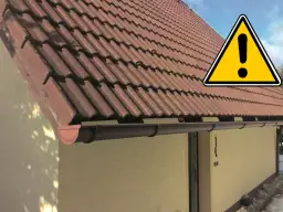Uwaga na dach! Brązowe dachówki i rynny tworzą opierzenie dachu, które wymaga uwagi.