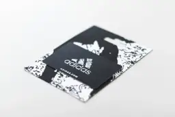 Czarny voucher Adidas z logo i adresem strony internetowej. Dowiedz się, jak zrobić voucher na prezent.