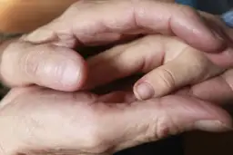Dłonie dorosłego i dziecka splatają się. Sen o śmierci dzieci może symbolizować koniec pewnego etapu.
