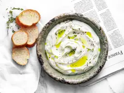 Labneh co to? Kremowy serek jogurtowy, skropiony oliwą, z ziołami i pieprzem, podany z chrupiącymi grzankami.