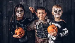 Dzieci w strojach szkieletów z dyniami. Zobacz, jak pomalować dziecko na Halloween, by wyglądało przerażająco!