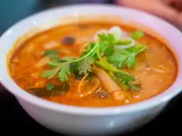 Aksamitna zupa tom yum z krewetkami, grzybami i świeżą kolendrą. Aromatyczny, pikantny bulion zachęca do spróbowania.