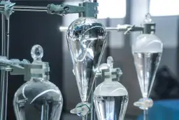 Laboratory setup z kolbami do rozdzielania cieczy. Woda destylowana a demineralizowana – czystość w nauce.