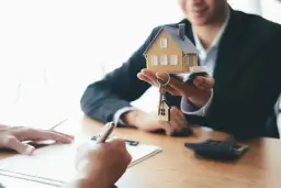 Agent présentant une maquette de maison et des clés, symbolisant la vente du bien et le droit de retour conventionnel.
