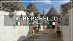 Alberobello, miasto domków trulli, z rowerem ozdobionym kwiatami i wiszącą na ścianie czosnkiem.