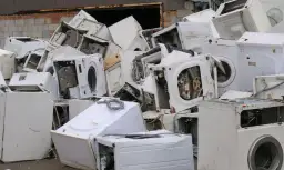 Góra złomu ze starymi pralkami. Zastanawiasz się, co zrobić ze starą pralką? Tutaj znajdziesz odpowiedź – to miejsce na recykling.