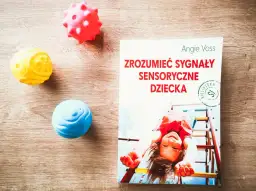 Książka "Zrozumieć sygnały sensoryczne dziecka" i kolorowe piłeczki terapeutyczne. Jak pomóc dziecku z zaburzeniami sensorycznymi?