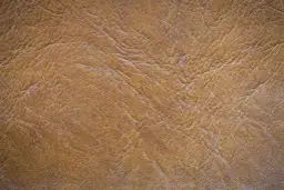 Textura de piel de serraje marrón con arrugas y pliegues. Este material es resistente y la piel de serraje se puede mojar sin problemas.