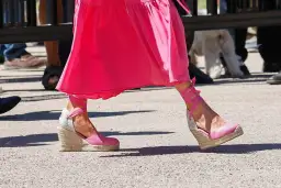 Pie de la Reina Letizia luciendo unas alpargatas de cuña rosas con cintas atadas al tobillo, combinadas con un vestido fucsia.