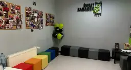 W poczekalni "Świat Zagadek" wiszą zdjęcia z przygód, balony i kolorowe pufy.