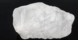 Surowy, biały ałun, minerał o szklistym połysku, z widocznymi wewnętrznymi pęknięciami.