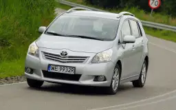 Srebrny Toyota Verso S jedzie po drodze, za kierownicą siedzi osoba.