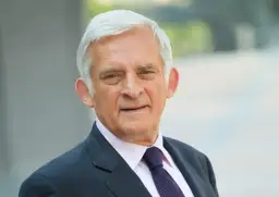 Jerzy Buzek, były premier i przewodniczący Parlamentu Europejskiego, w eleganckim garniturze. Jego poprzednie urzędy świadczą o bogatym doświadczeniu politycznym.