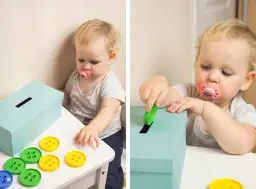 Dziecko bawi się pudełkiem z otworami i kolorowymi przyciskami, tworząc własne zabawki montessori diy.