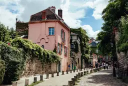 Urocza, zielona uliczka w Paryżu. Czy 18 dzielnica Paryża jest bezpieczna? Wygląda na spokojną, z pięknymi domami i spacerującymi ludźmi.
