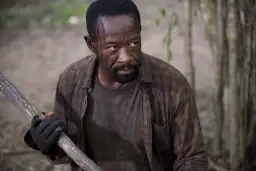 Morgan z "The Walking Dead 6" z kijem w ręku, gotowy do walki w lesie.