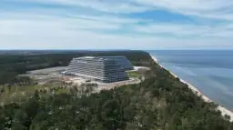 Ogromny hotel Gołębiewski w budowie, zlokalizowany przy morzu, otoczony lasem sosnowym.