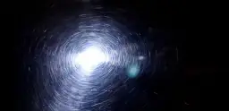 Efekt wiru po polerowaniu lakieru po malowaniu sprayem. Jasne światło odbija się od powierzchni, tworząc spiralne refleksy.