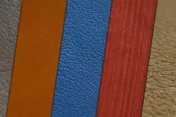 Muestras de materiales: cuero vegano azul, naranja y marrón, junto a un material rojo con vetas.